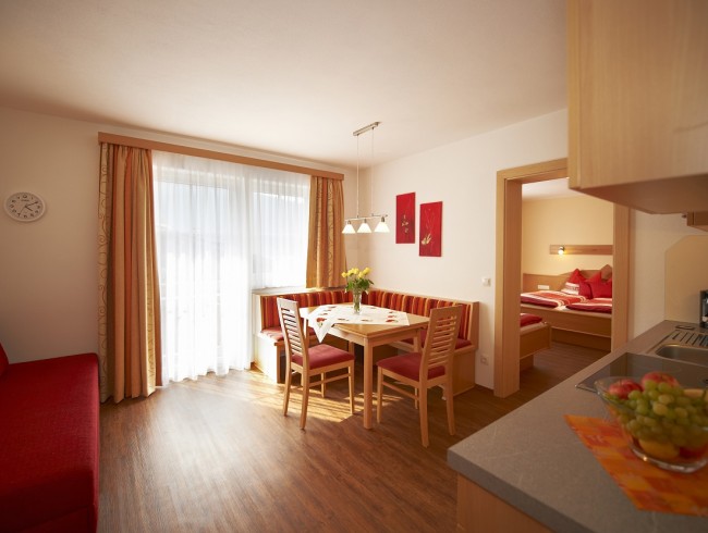 Wohnküche mit Balkon, Esstisch und Küchenzeile